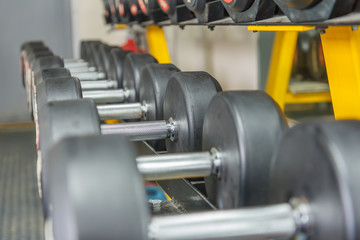 Obraz premium Rows of dumbbells in the gym wait for those who will exercise to use,lifting dumbbell helps build many muscles, depending on the posture.
