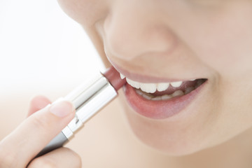 Naklejka premium A woman is using lipstick