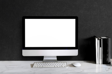 Stylish workspace with desktop computer, office supplies, houseplant and books at home or studio. Blank screen for graphics display montage.