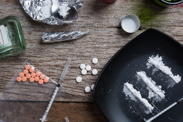 alcohol, drugs, pills on a wood background