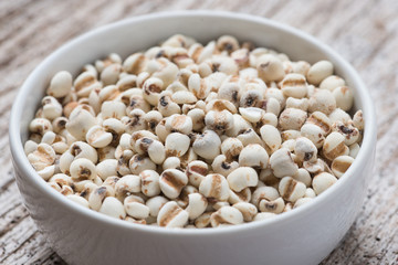 Job's tears in bowl on rustic wooden table