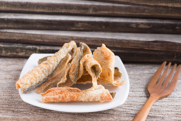 Crispy fried salmon skin on wood background