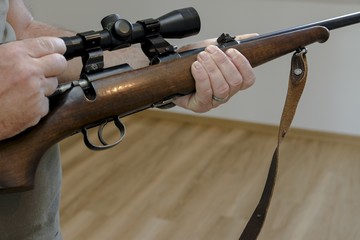 man is pointing his gun out of the window