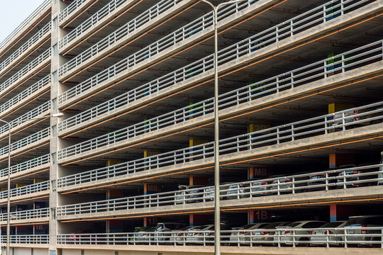 Parking garage or parking lot building with vehicles. It has large ten-story high.