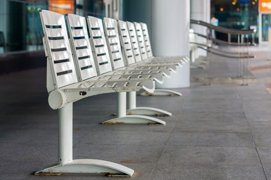 Modern seating at bus stop. The white seats are made of metal.