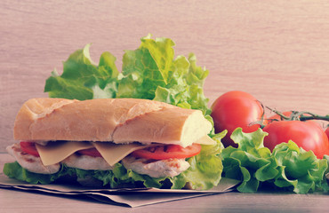 sandwich baguette with chicken breast, cheese and tomatoes