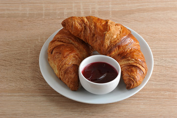 two Golden croissant with jam on a plate