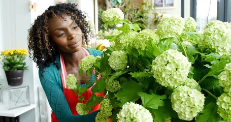 Female florist arranging flower in flower shop - Powered by Adobe