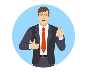 Businessman with mobile phone showing thumb up