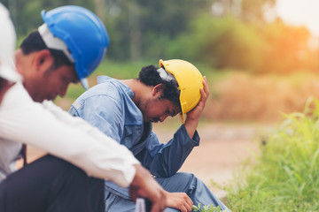 Group of Businessman/Engineering/ Architect Feeling exhausted is working on pressure, while wearing protective equipment safety helmet at construction site,  stressed business concept.