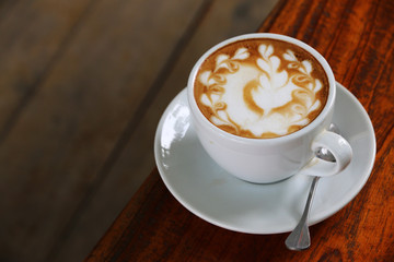 Hot latte coffee On the old wood table in the morning.Copy space for your text.