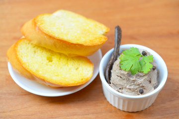 Chicken liver pate with bread on a wooden table. Top view