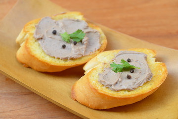 Chicken liver pate with bread on a wooden table. Top view