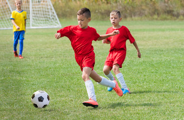 Obraz premium Kids soccer football - children players match on soccer field