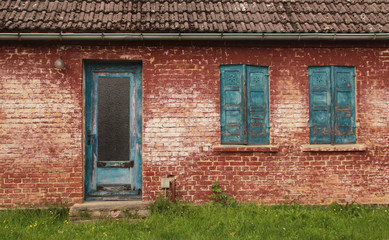 Fototapeta na wymiar altes Ziegelhaus mit verwitterten Türen und Fenstern
