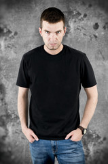Angry man in black t-shirt on grunge background