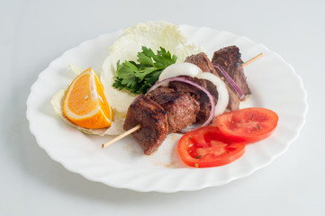 Beef pork barbecue kebab on skewer on a white plate