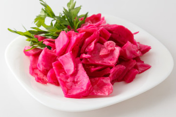 beets salad with greens on a white plate