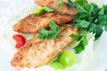 fish in batter with greens on a white plate