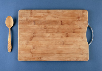kitchen cutting board and a wooden spoon on a blue