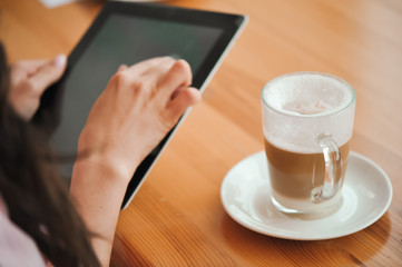 girl in cafe uses small mobile computer