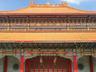 Chinese buddhist temple from front view, consisting of roof and entrance gate, decorated in red and yellow