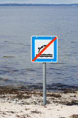 Prohibition sign next to old wooden pier in Langeland, Denmark forbidding jumping from the pier