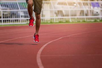 man running in the track. Fit male fitness runner jogging in stadium