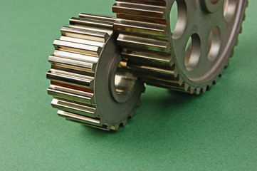 Two gears on a green background