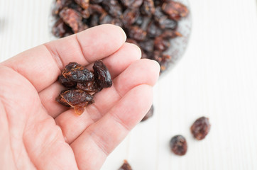 Hand mit getrockneten Cranberries, Holzhintergrund