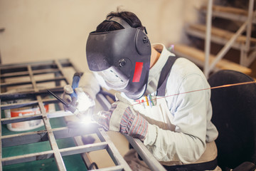 Industrial Worker labourer at the factory welding steel structure