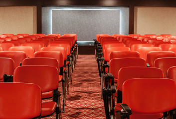 rows of red chairs in empty conference hall