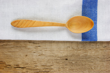 wooden spoon and dishcloth on old wooden table
