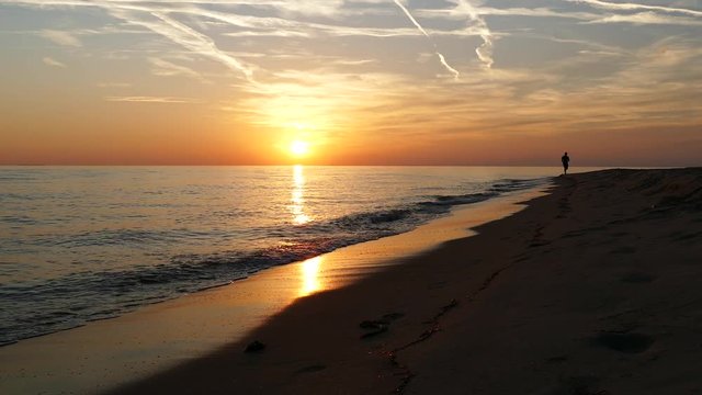 Guy running at keramoti beach during sunset in Greece