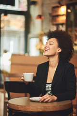 Businesswoman taking break and drinking coffee in cafe