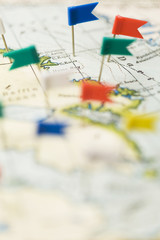 Flag shaped push pin in a vintage travel map. travel destination planning concept