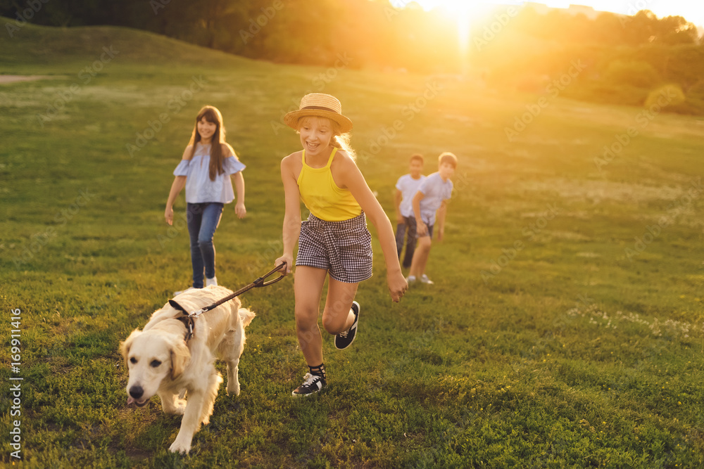 Wall mural teenagers with dog walking in park