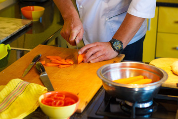 Girl's hand with a knife cutting lemon on wooden Board