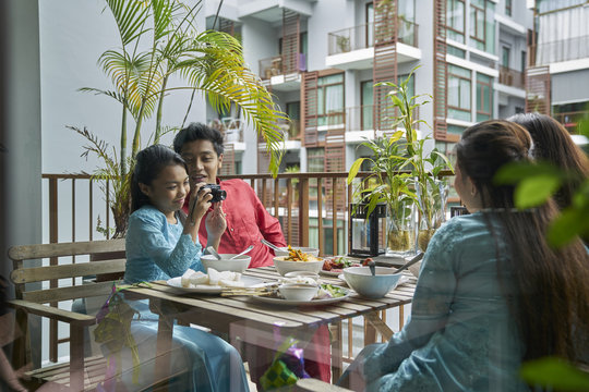 Family Taking Photographs At The Balcony During Hari Raya