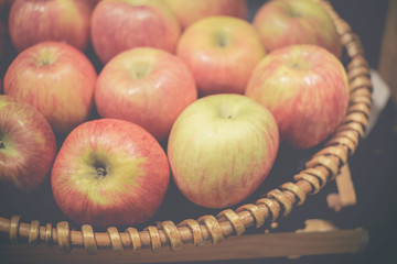 Freshly colored apples are in rattan baskets.