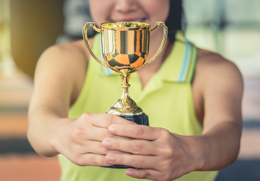 Teenage girls' hands are holding trophies, congratulations on success.Conception of victory in the competition.Focus on the trophy