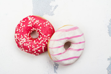 Sweet pink and white donuts on white background. Copy space
