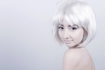 Portrait of young woman / female / girl with white care wig / hair and bare shoulders posing