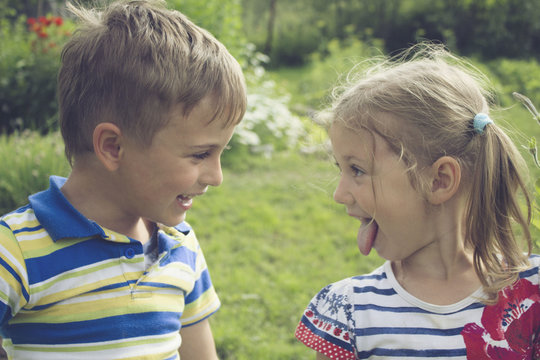 A Boy And A Girl Laughing In The Park On Summer Day