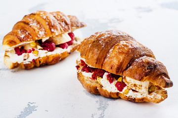 French croissants with cream cheese and raspberry, cinnamon and almond nuts. Copy space