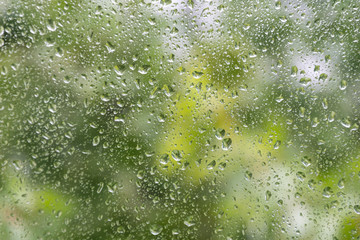 Water drops on glass with blury green background