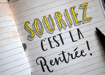 « SOURIEZ, C’EST LA RENTREE » lettrage à la main sur cahier