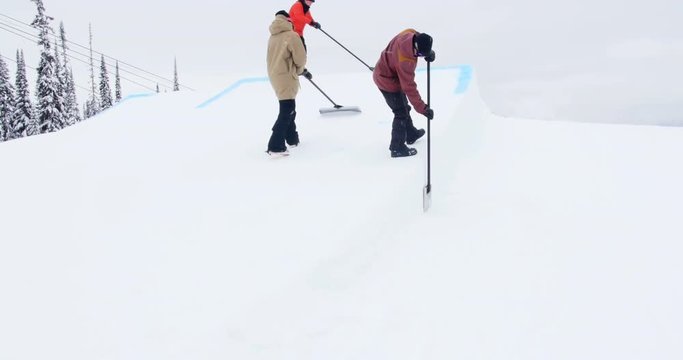 Group of man cleaning snow in ski resort
