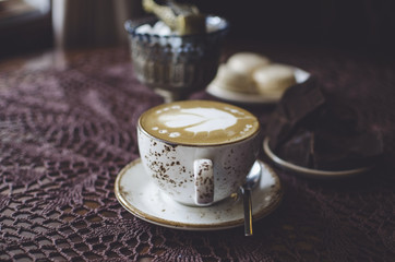 Breakfast on the retro cafe with cappuccino and macaroons. Coffee latte with chocolate
