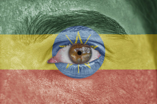 Human face and eye painted with flag of Ethiopia